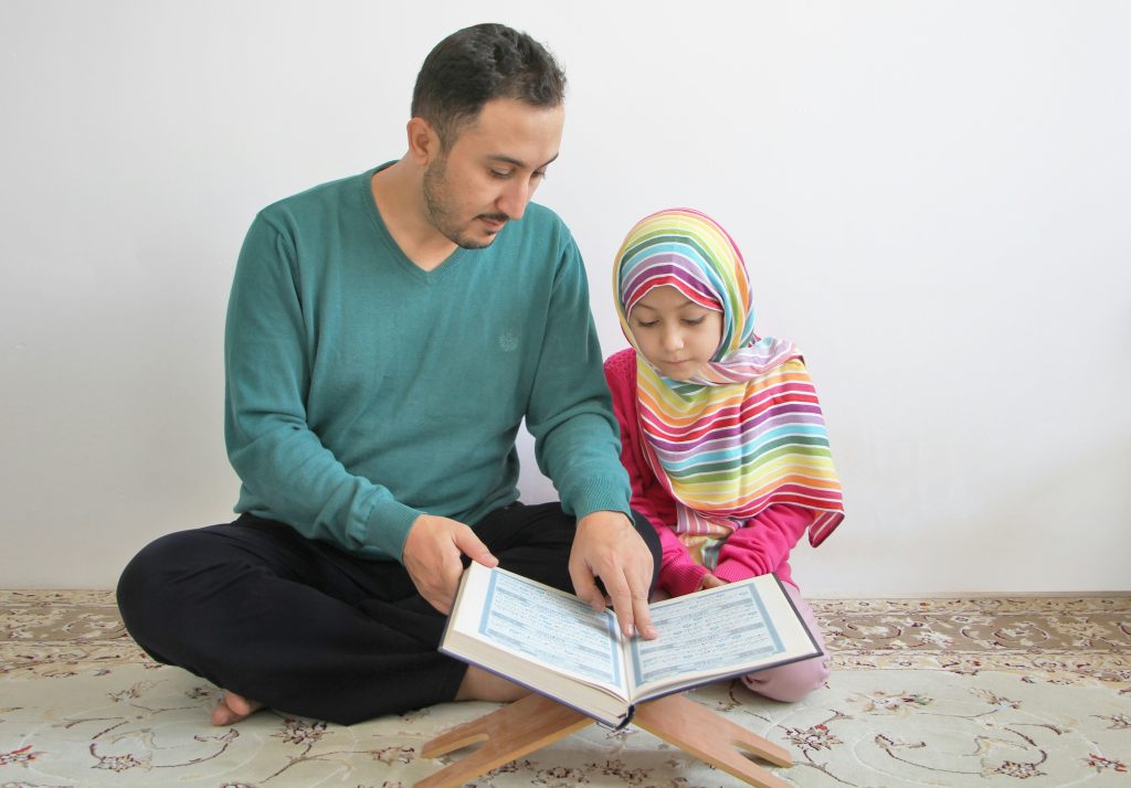 A father and his daughter are reading the Quran