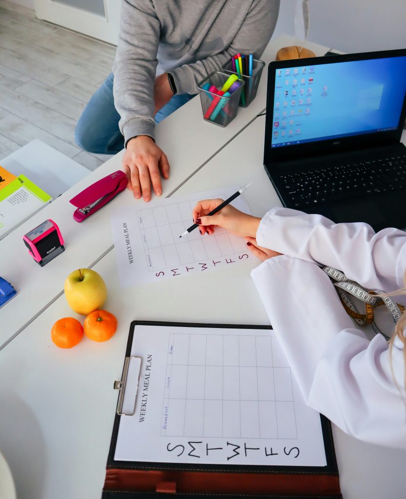 Teacher with parent and child in a collaborative meeting; notes on the table