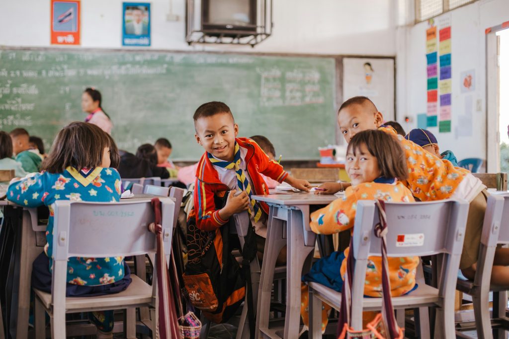 child multicultural classroom smiling inclusive school