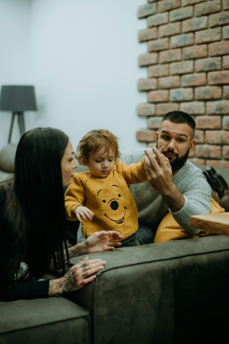 child speaking happily two adults family home warm light