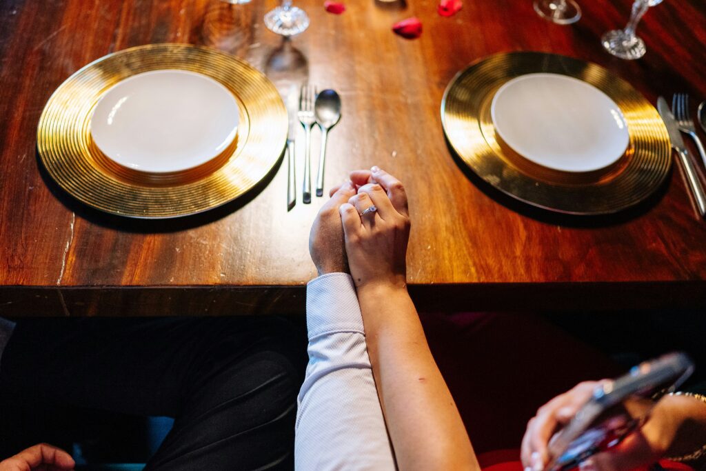 hands holding around dinner table