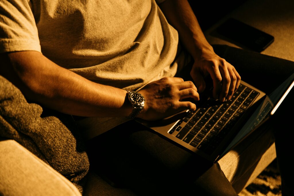 person typing laptop evening light warm