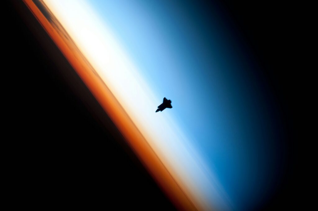 A spaceship orbiting with bioluminescent trails