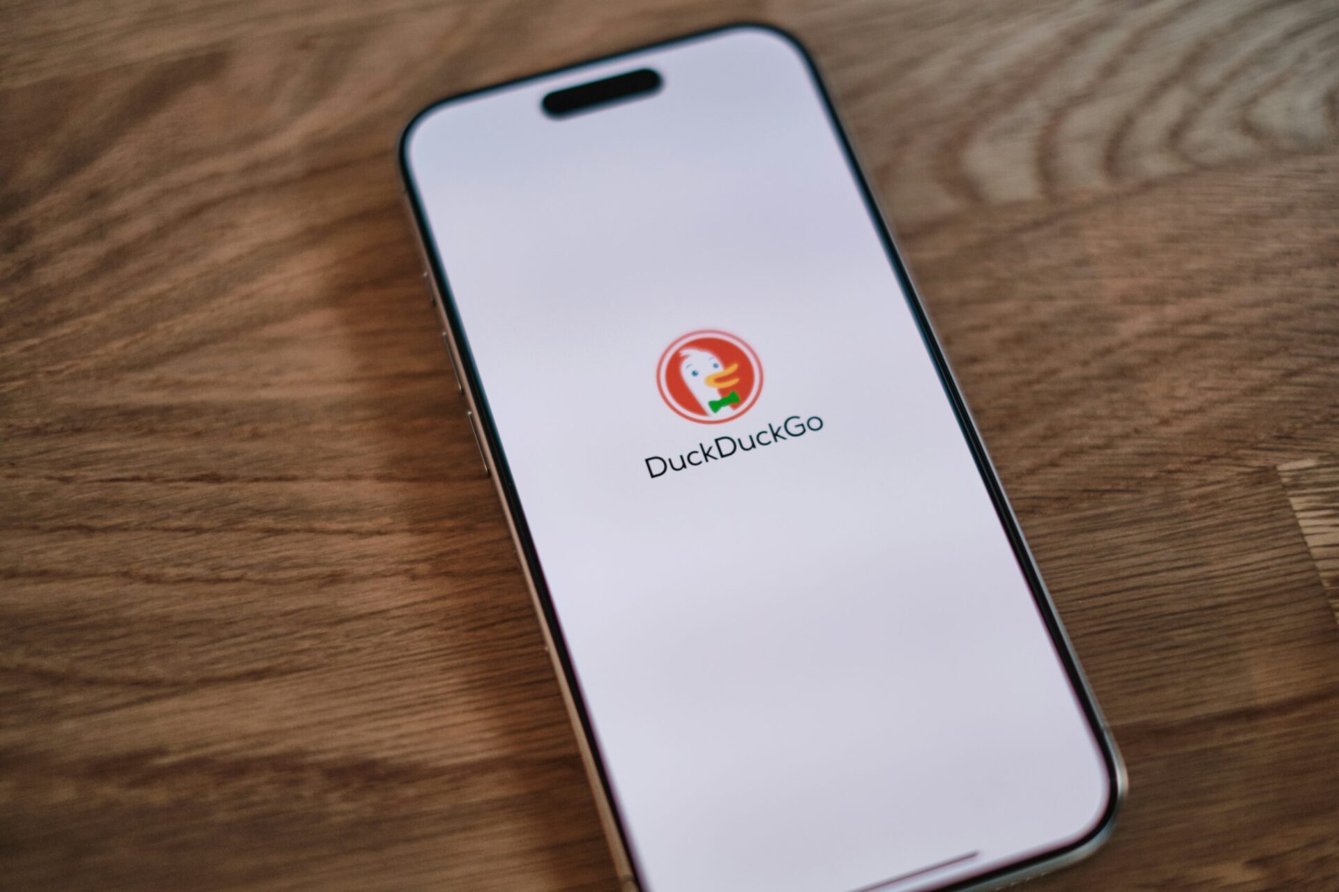 A mobile phone displaying the DuckDuckGo logo on its screen.